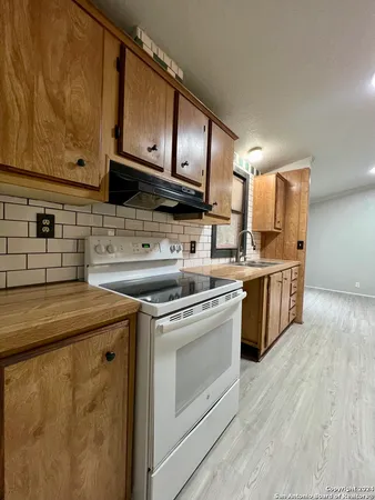 a kitchen with stainless steel appliances granite countertop a sink a stove and a microwave oven with cabinets