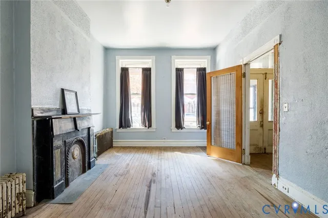 a view of a hallway with wooden floors and a fireplace
