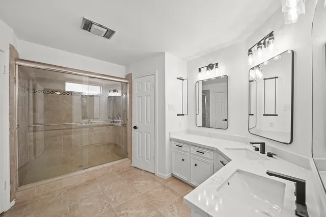 a bathroom with a double vanity sink toilet mirror and bathtub