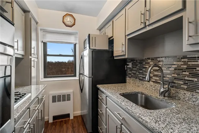 a kitchen with granite countertop a sink a stove and refrigerator