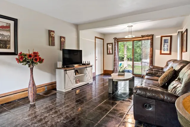 a living room with furniture a flat screen tv and a floor to ceiling window
