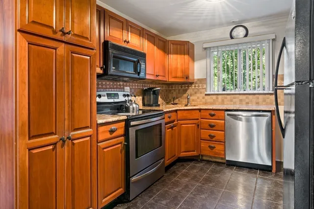 a kitchen with stainless steel appliances granite countertop a refrigerator a stove a sink and dishwasher