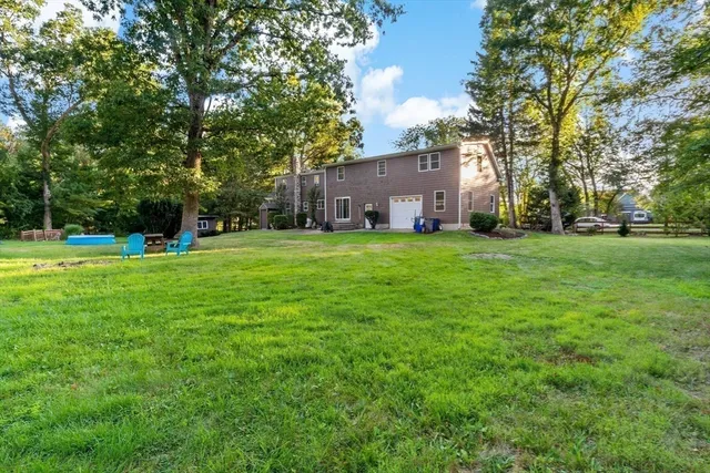 a view of a house with a big yard and large trees