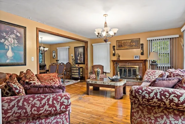a living room with furniture a fireplace and a chandelier
