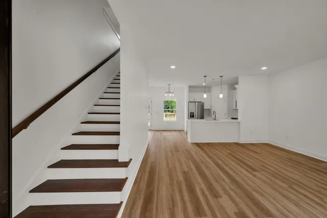 a view of a big room with wooden floors and stairs