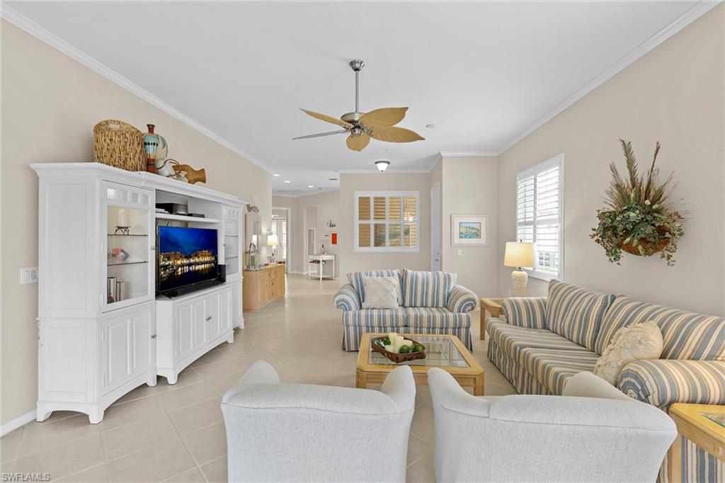 4541 Cardinal Cove Lane Naples, FL 34114 - Photo 4 of 42 a living room with furniture a flat screen tv and a chandelier