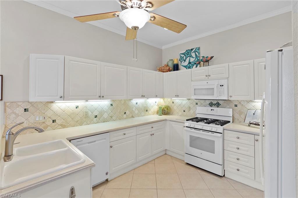 4541 Cardinal Cove Lane Naples, FL 34114 - Photo 8 of 42 a kitchen with cabinets stainless steel appliances and a chandelier