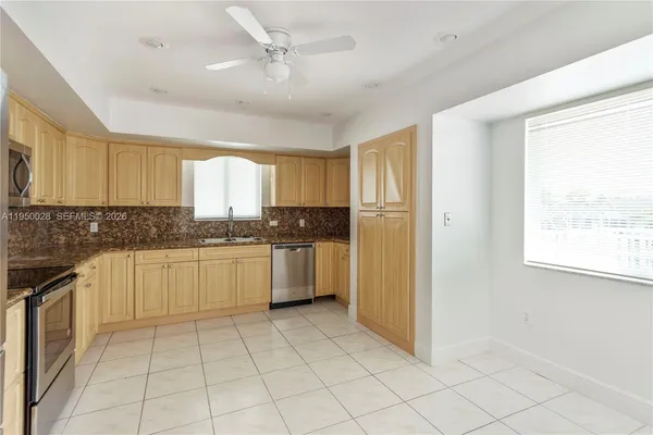 a large kitchen with a stove a sink dishwasher and a refrigerator