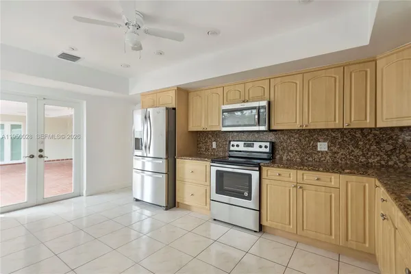 a kitchen with stainless steel appliances granite countertop a refrigerator and a stove top oven