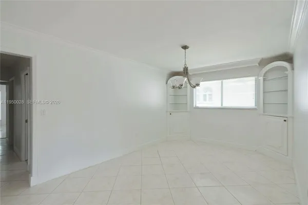 a view of empty room with window and chandelier