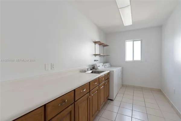 a view of a kitchen with a sink washer and dryer