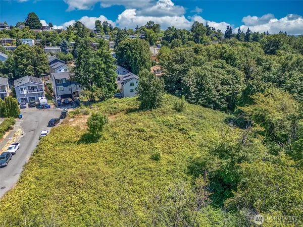 an aerial view of residential house with outdoor space and trees all around