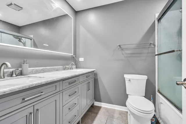 a bathroom with a granite countertop toilet sink and a mirror