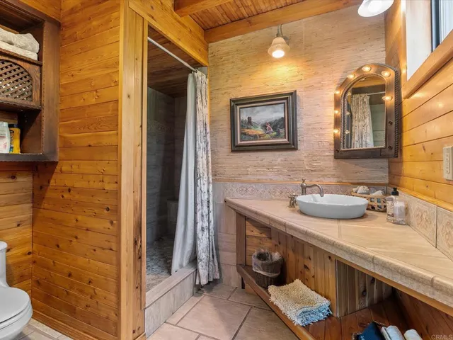 a bathroom with a granite countertop sink a toilet and a mirror