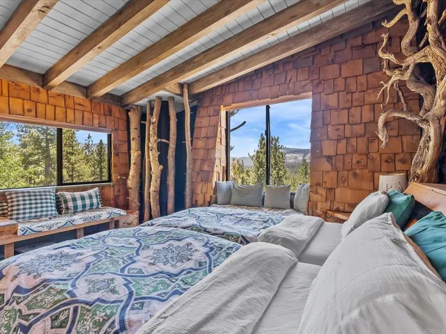 a bedroom with a bed and a large window with outer view