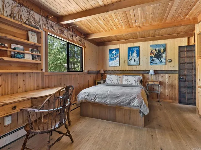 a bed sitting in a spacious bedroom next to a window
