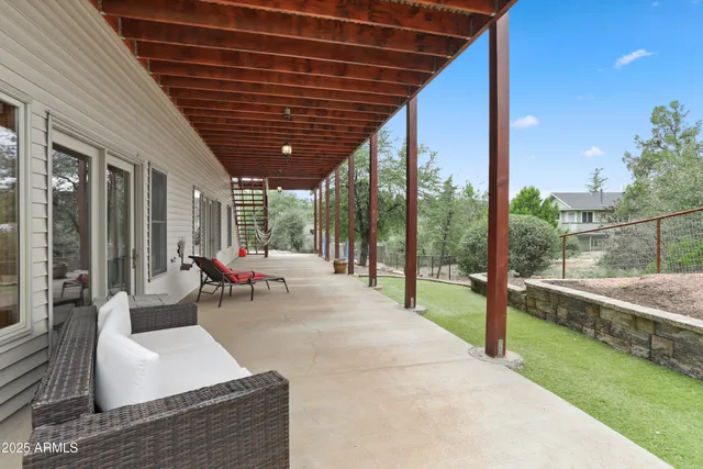 a living room with patio furniture and a garden