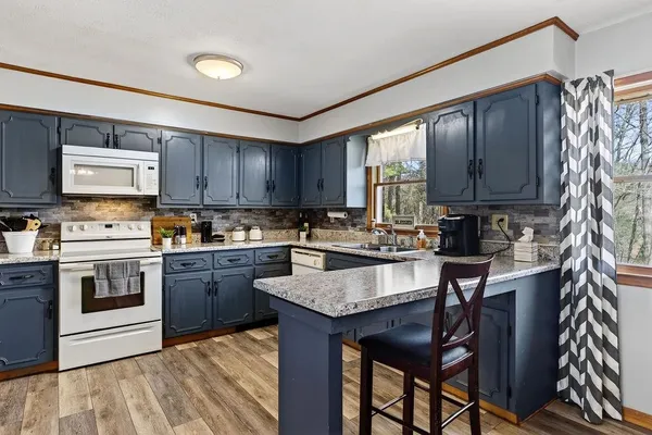 a kitchen with stainless steel appliances granite countertop wooden cabinets a stove top oven a sink and dishwasher