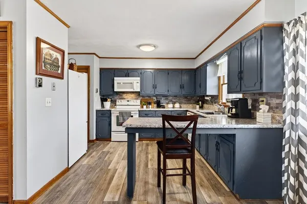 a kitchen with stainless steel appliances granite countertop a refrigerator a sink dishwasher a stove with wooden cabinets and floor