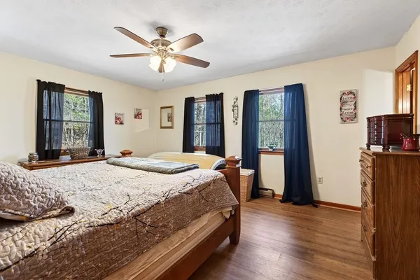 a bedroom with a large bed a flat tv screen and dresser