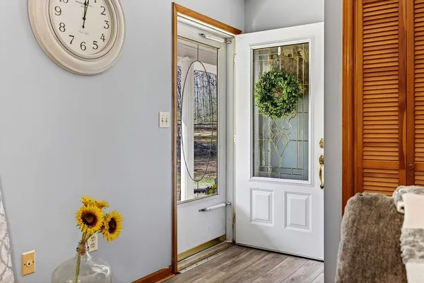 a view of a hallway with entryway wooden floor and front door
