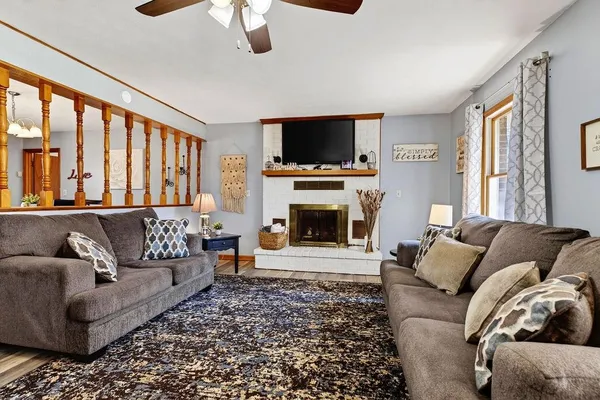 a living room with furniture a flat screen tv and a fireplace