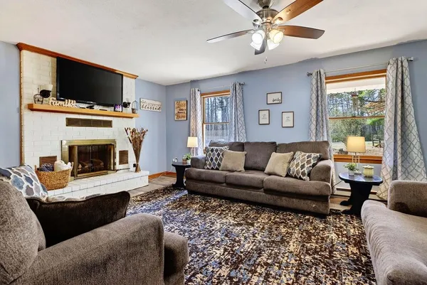 a living room with furniture a flat screen tv and a fireplace