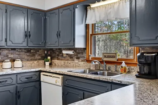 a kitchen with stainless steel appliances granite countertop a sink a stove and cabinets