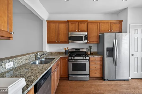 a kitchen with stainless steel appliances granite countertop a stove a refrigerator and a sink