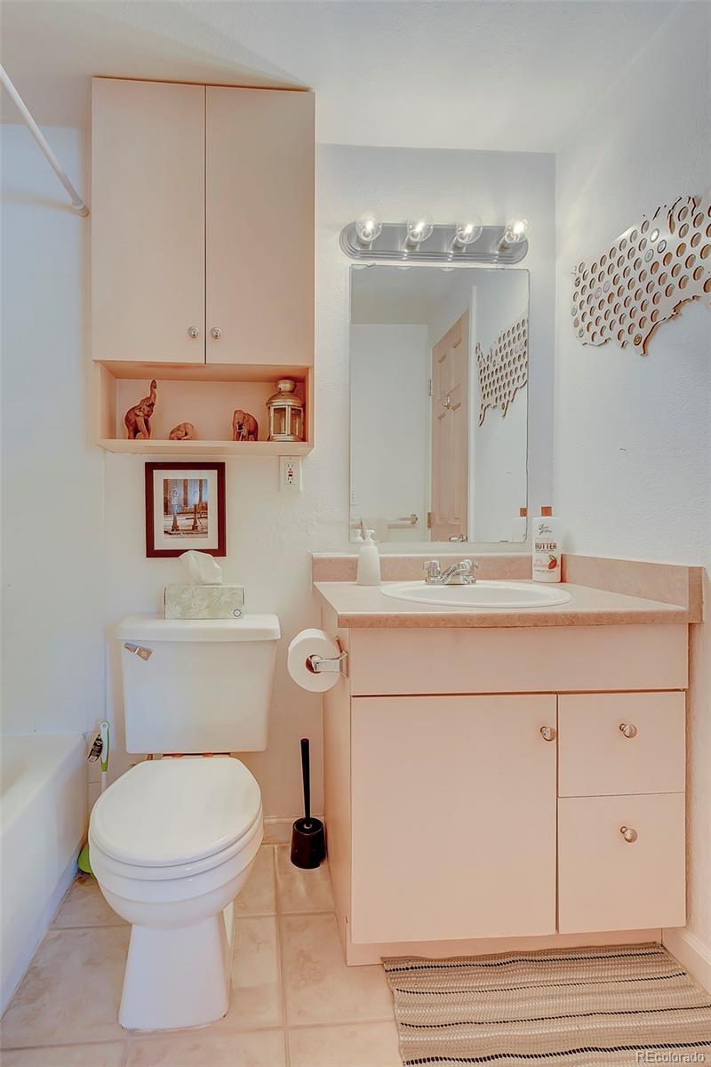 336 Grant Street, Unit 102 Denver, CO 80203 - Photo 12 of 22 a bathroom with a sink vanity granite toilet and a mirror