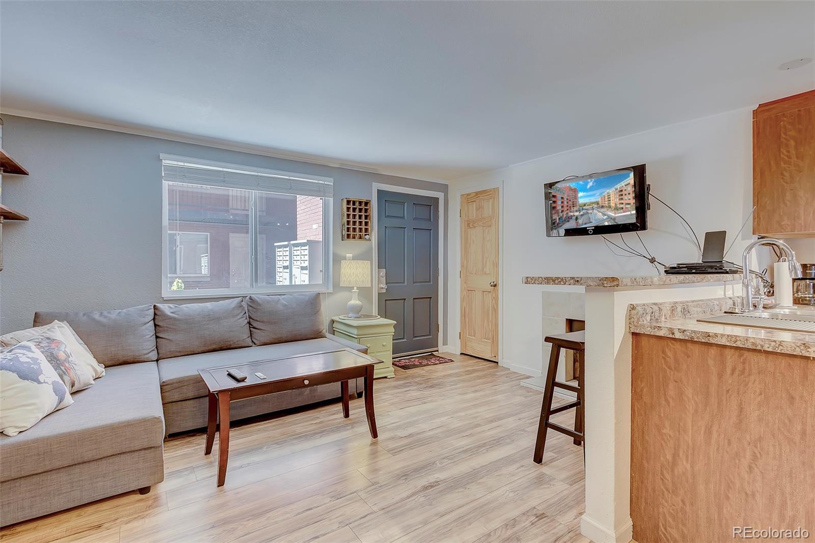 336 Grant Street, Unit 102 Denver, CO 80203 - Photo 2 of 22 a living room with furniture and a flat screen tv