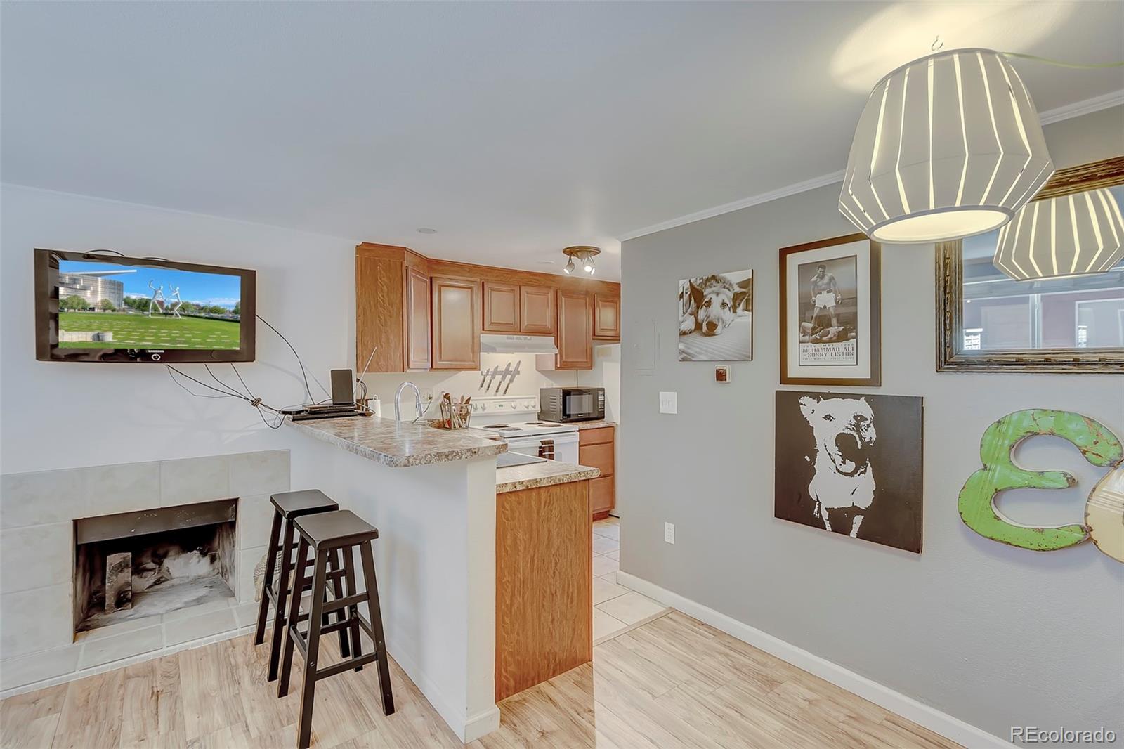 336 Grant Street, Unit 102 Denver, CO 80203 - Photo 3 of 22 a kitchen with stainless steel appliances granite countertop a refrigerator and a stove top oven with wooden floor