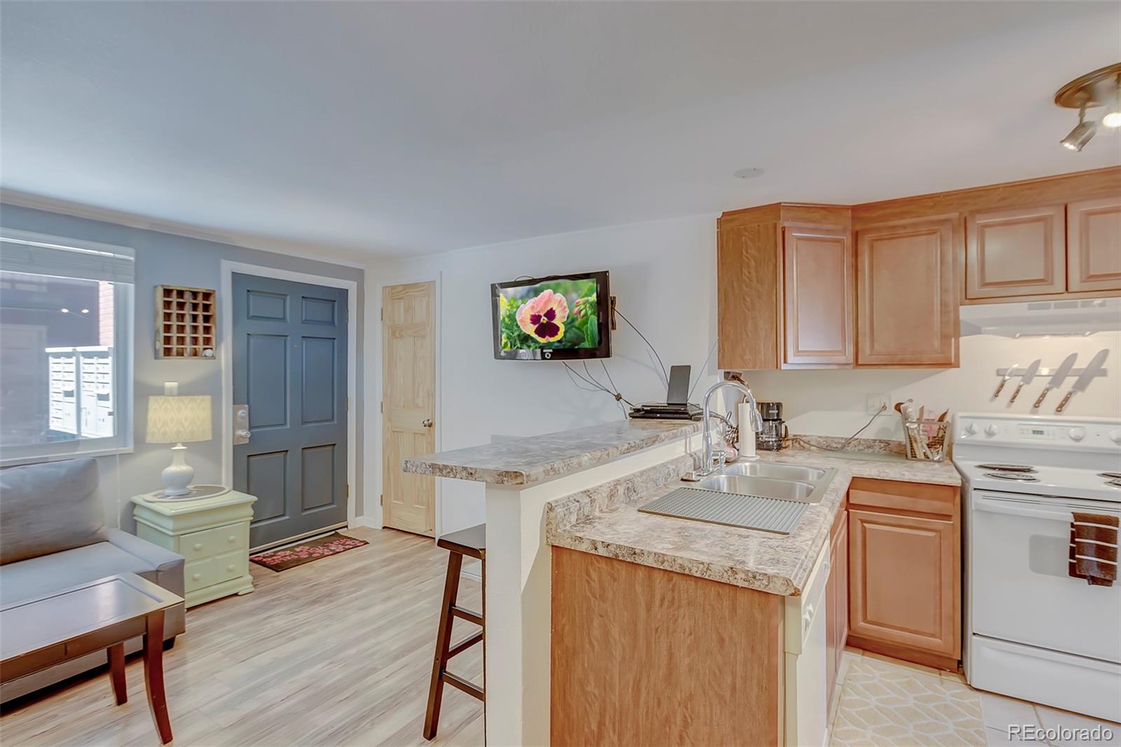 336 Grant Street, Unit 102 Denver, CO 80203 - Photo 6 of 22 a view of a kitchen area with furniture and wooden floor