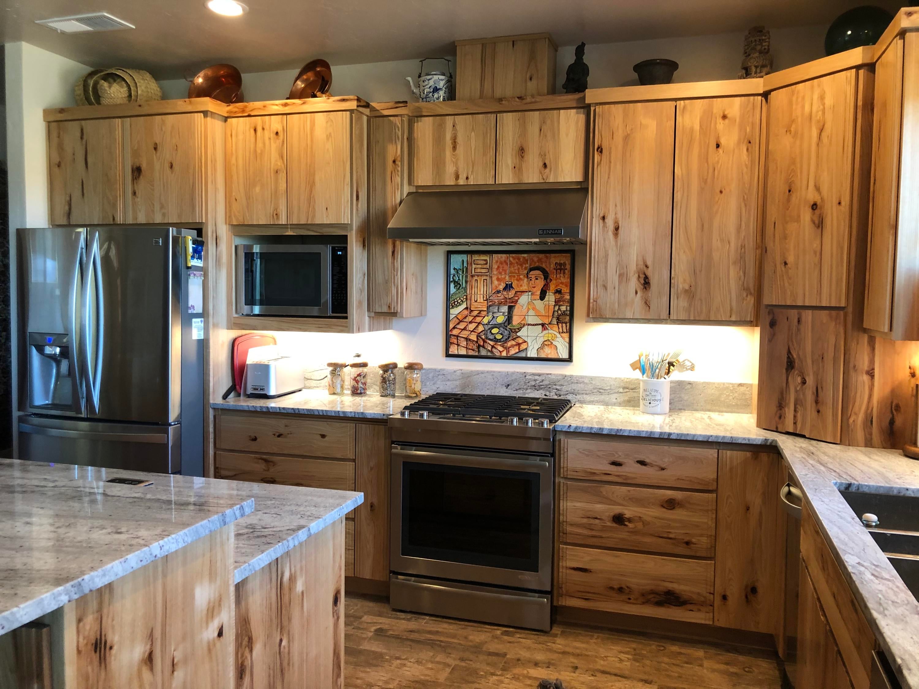 22063 Rickard Road Bend, OR 97702 - Photo 10 of 29 Kitchen has hand-painted tile mural over 5 burner stove. Applicance gaage in corner, Knotty hickory cabinets.