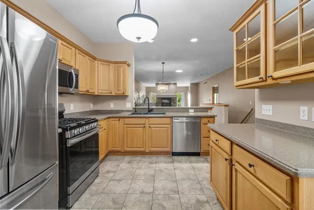 a kitchen with a sink window and stainless steel appliances