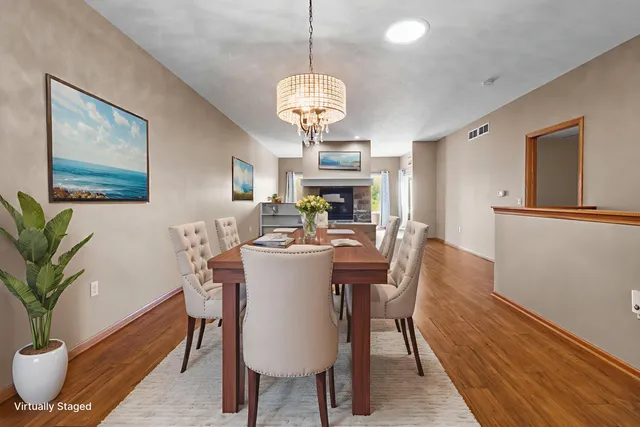 a dining room with furniture potted plants and wooden floor