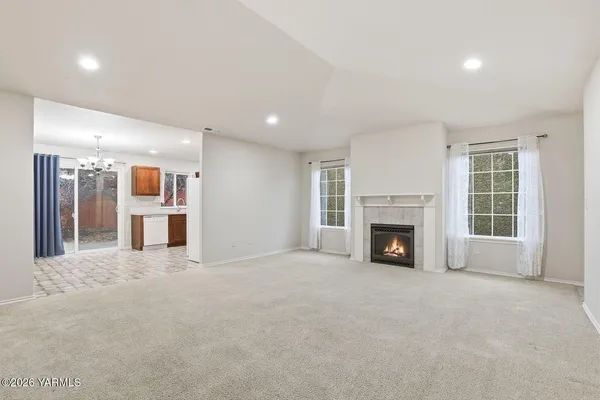a view of an empty room with a fireplace and a window