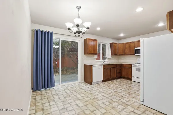 a kitchen with stainless steel appliances kitchen island granite countertop a refrigerator and a sink