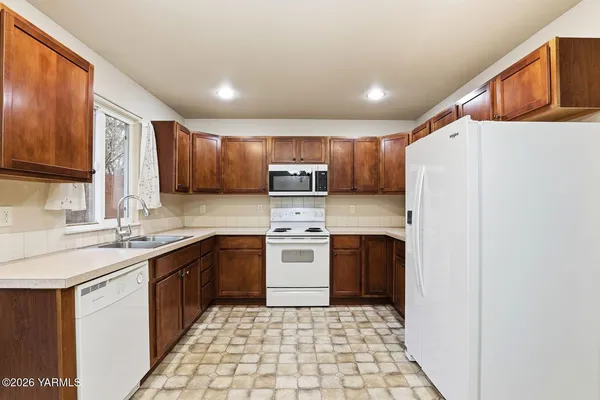 a kitchen with stainless steel appliances granite countertop a refrigerator sink and cabinets