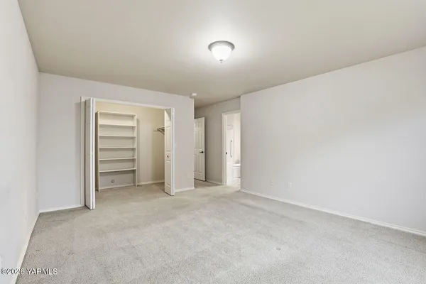 a view of an empty room and closet area
