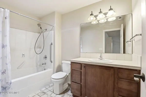a bathroom with a granite countertop sink mirror toilet and bathtub