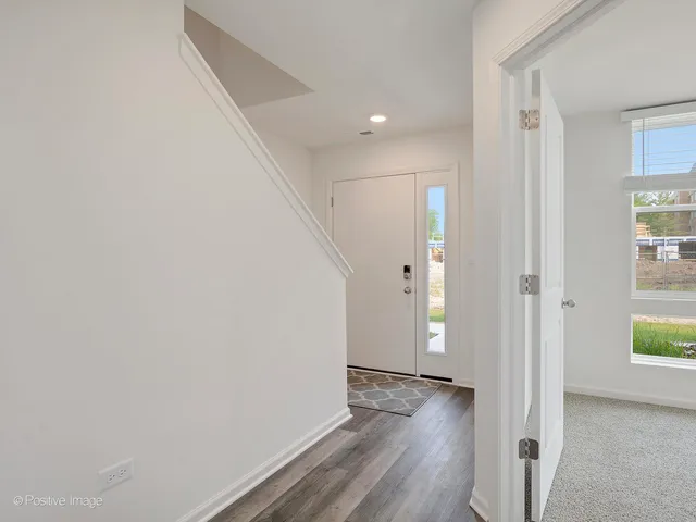 a view of an empty room with wooden floor and windows