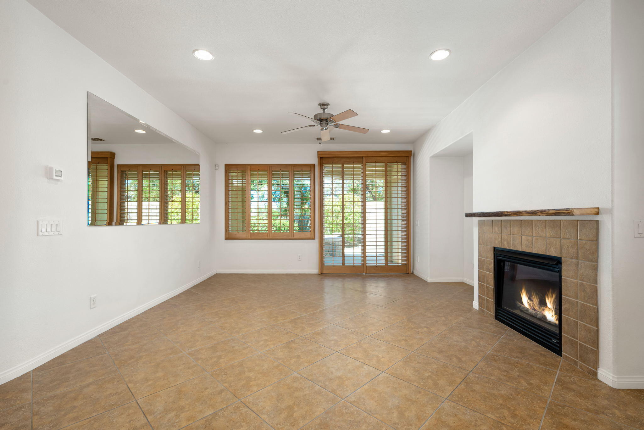 49728 Pacino Street Indio, CA 92201 - Photo 14 of 54 an empty room with windows and fireplace