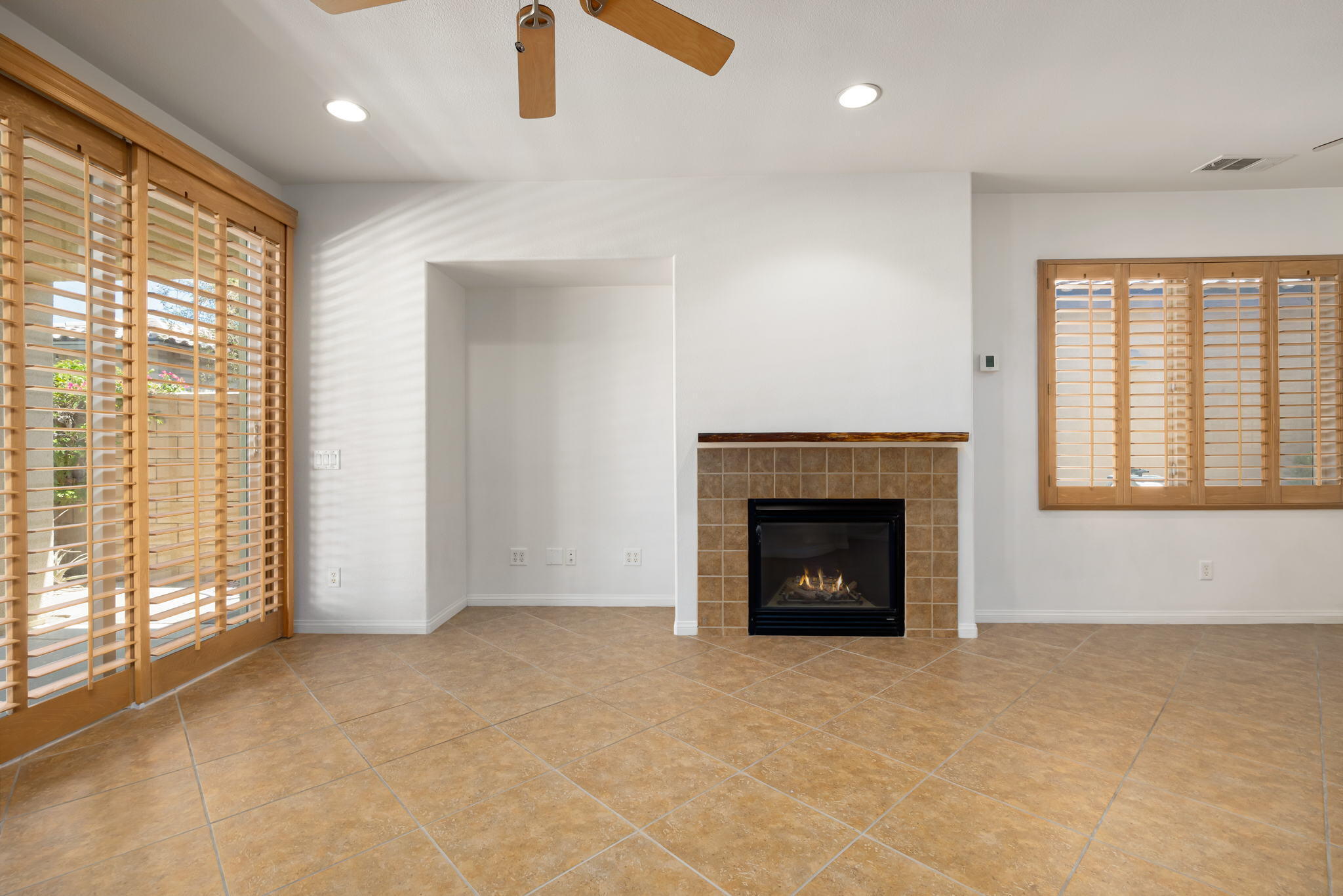 49728 Pacino Street Indio, CA 92201 - Photo 16 of 54 a view of an empty room with a fireplace and a window