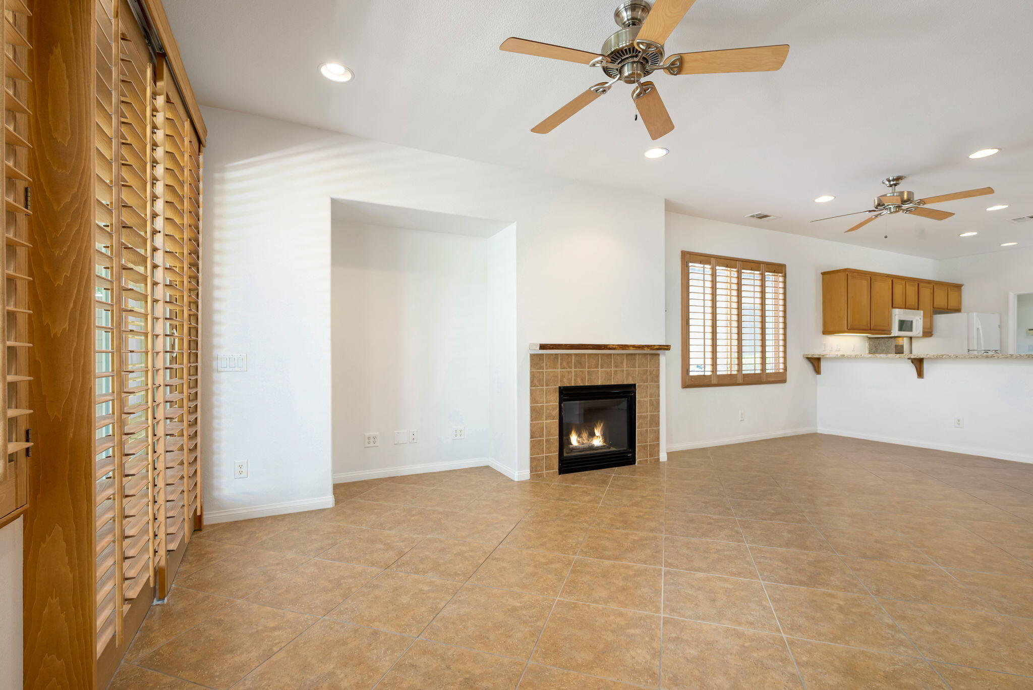 49728 Pacino Street Indio, CA 92201 - Photo 17 of 54 a view of an empty room with a fireplace and a chandelier fan