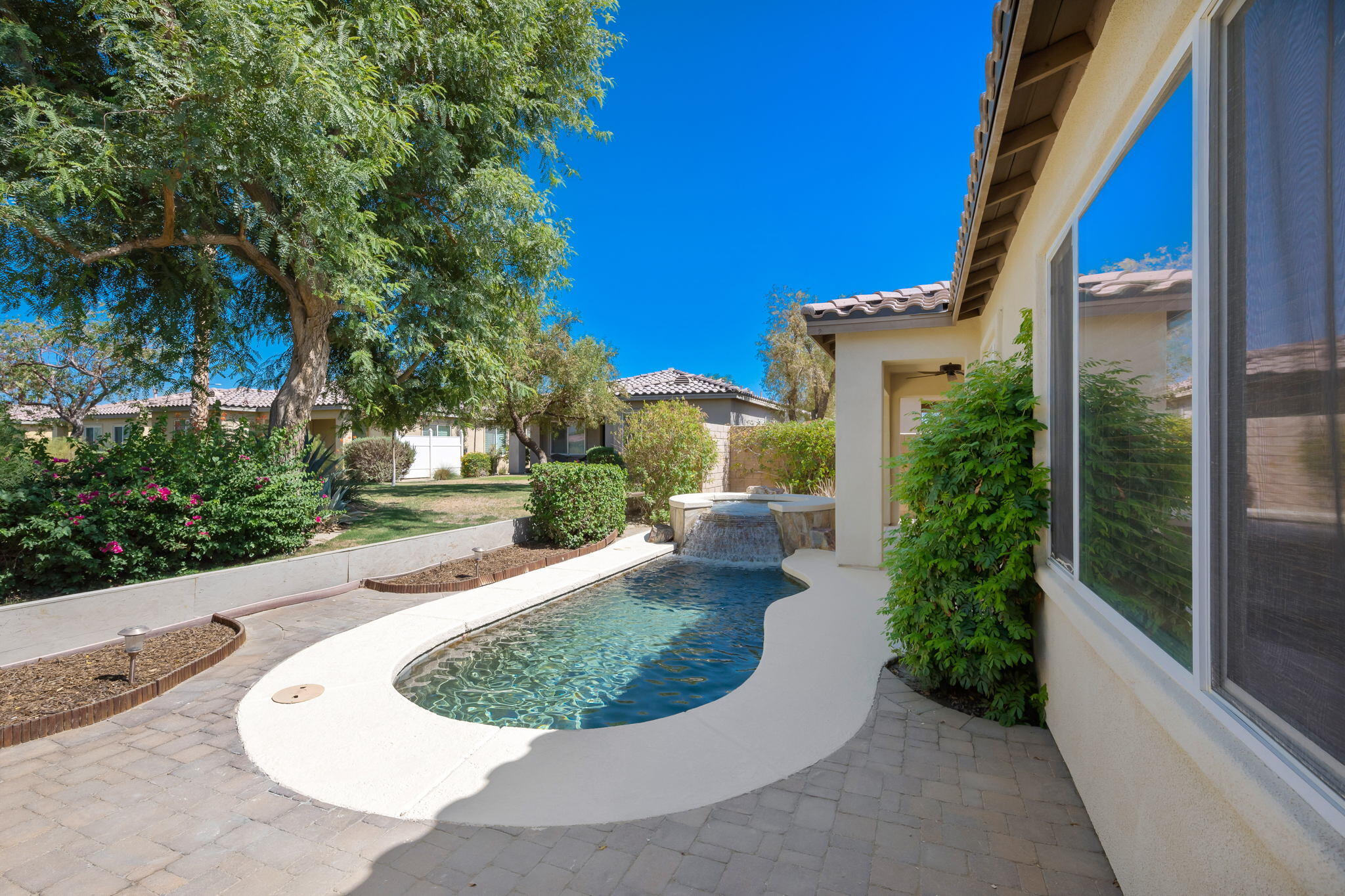 49728 Pacino Street Indio, CA 92201 - Photo 39 of 54 a view of a house with a small yard and potted plants