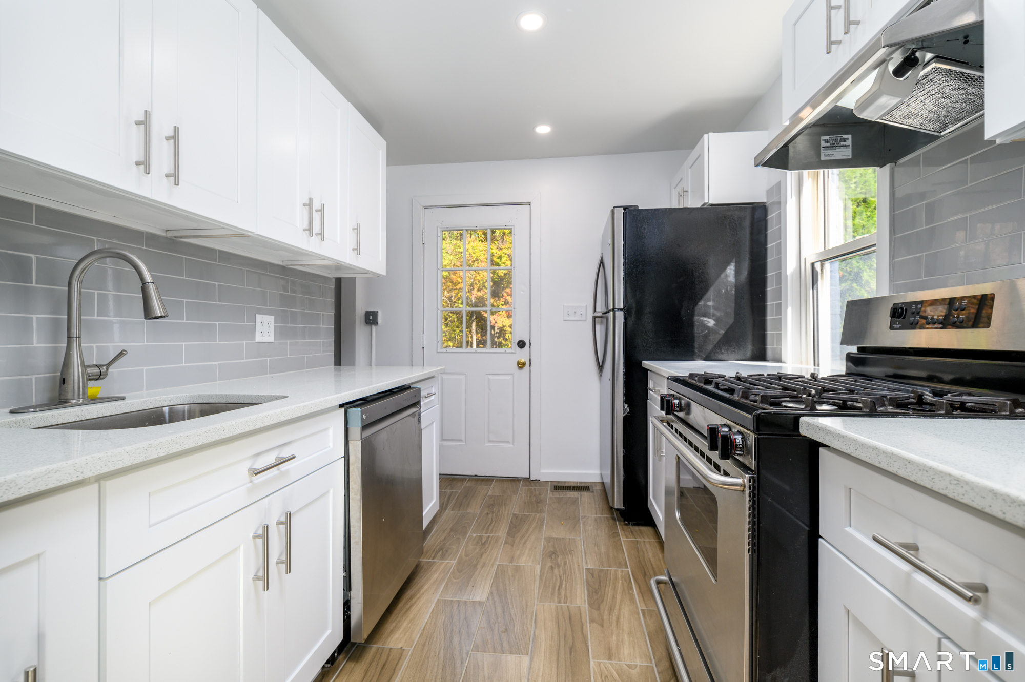 40 Beacon View Drive, Unit 2 Fairfield, CT 06825 - Photo 4 of 18 a kitchen with stainless steel appliances granite countertop a sink stove and refrigerator