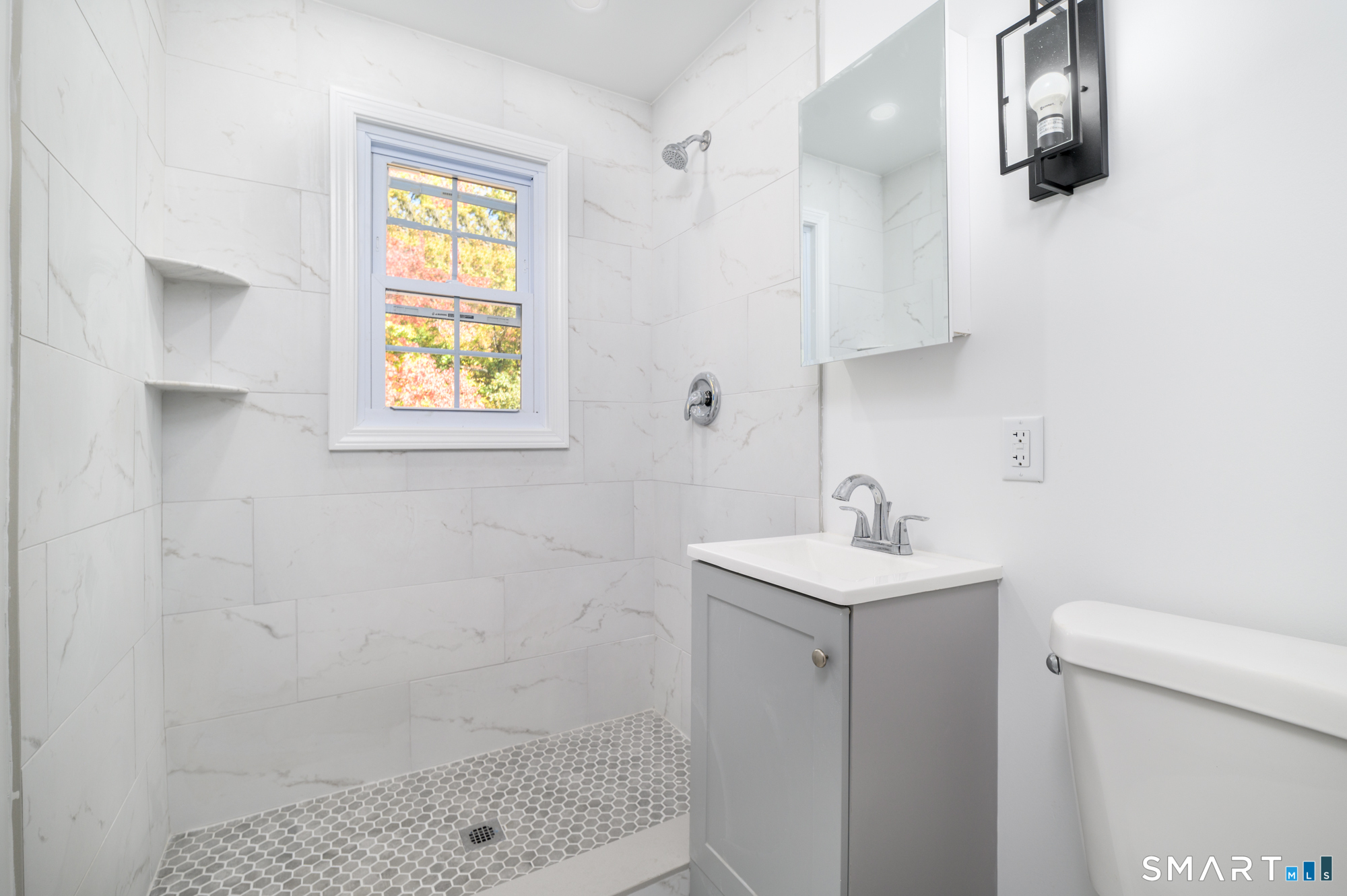 40 Beacon View Drive, Unit 2 Fairfield, CT 06825 - Photo 9 of 18 a bathroom with a sink a toilet and shower