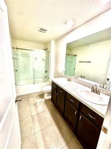 a bathroom with a granite countertop toilet sink and shower