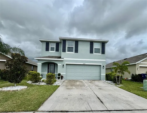 a front view of a house with a yard and garage